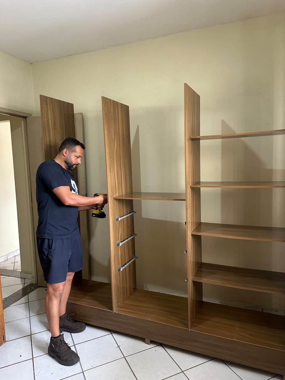 Profissional da Santos Log montando um guarda-roupa com ferramenta adequada