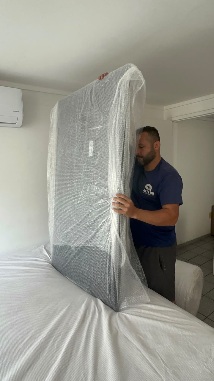 Profissional da Santos Log embalando cuidadosamente um item grande e delicado
